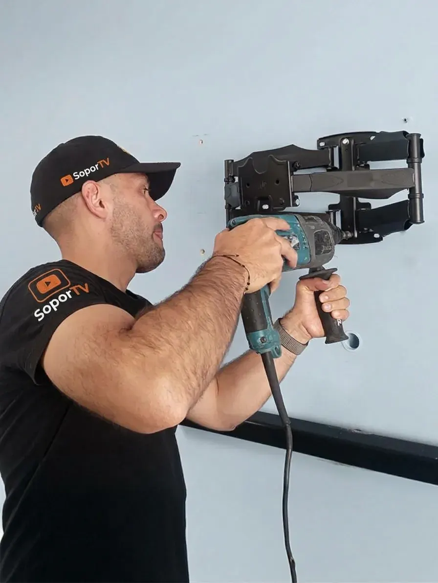 Técnico de SoporTV perforando la pared para fijar el soporte del televisor